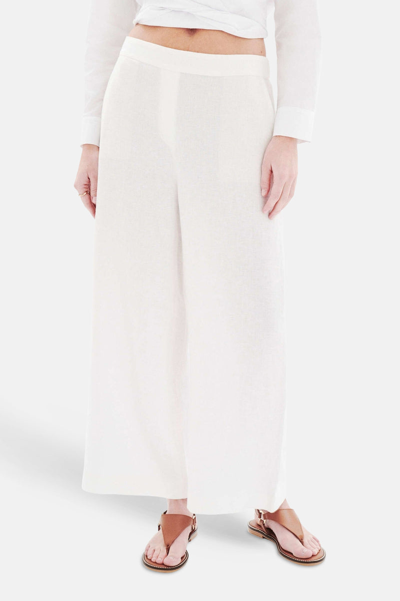 Witte broek met zakken van CAROLL, wijde pasvorm met bruine sandalen.