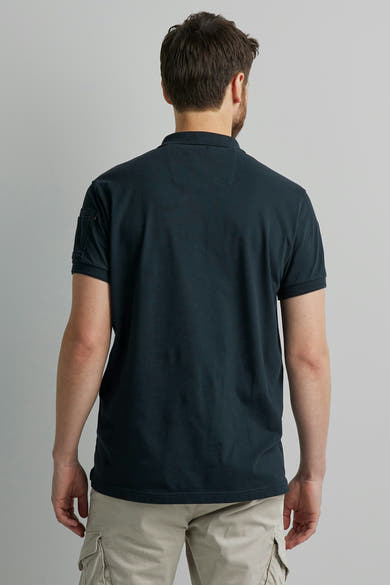 Polo bleu marine de Pme Legend, avec poche sur la manche, porté avec un pantalon cargo beige, vue de dos.
