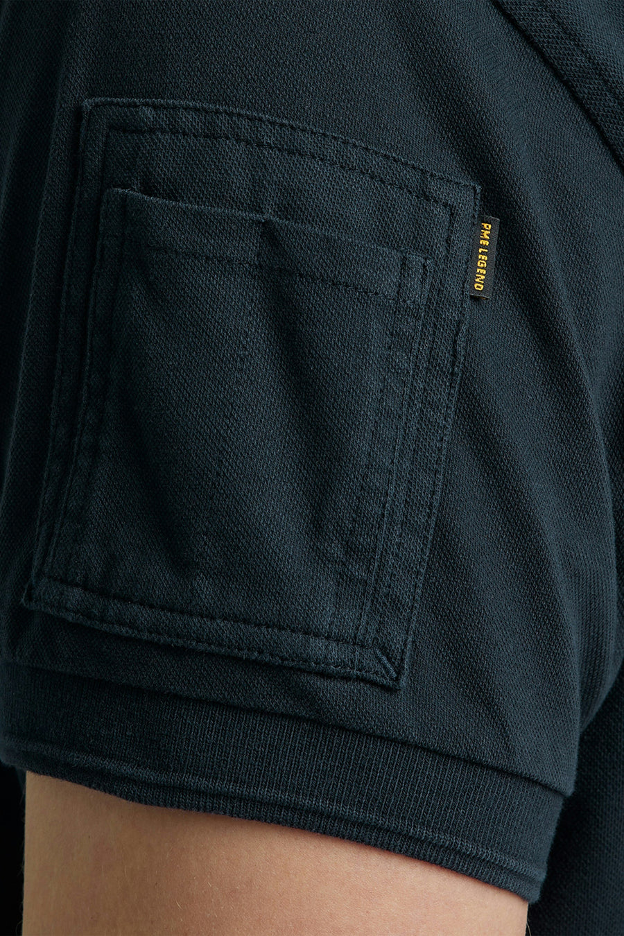 Polo bleu de Pme Legend, avec une poche poitrine carrée, et un badge logo discret.