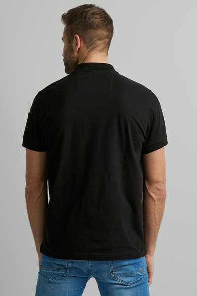 Polo noir de Pme Legend, porté avec un jean bleu, vu de dos.
