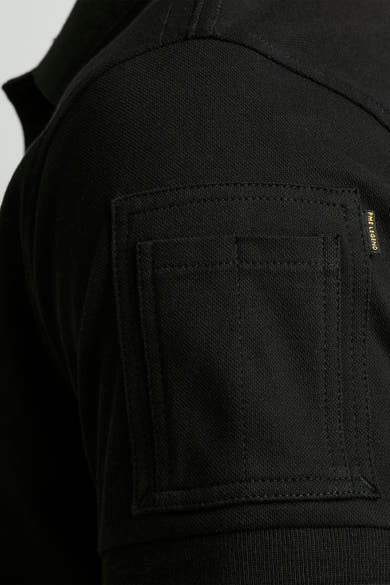 Polo noir de Pme Legend, avec une poche plaquée sur la poitrine.