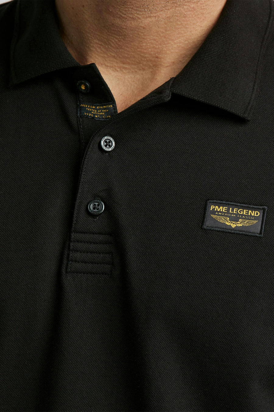 Polo noir de Pme Legend avec boutons de la marque et patch logo sur la poitrine.