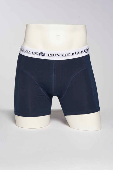Marineblauwe boxer van PRIVATE BLUE, op een hoofdloze paspop, met een witte elastische tailleband.