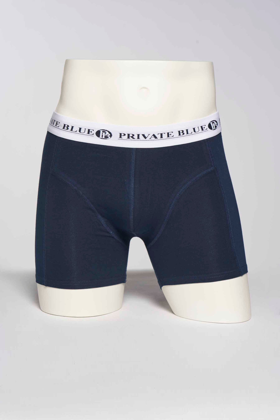 Marineblauwe boxer van PRIVATE BLUE, op een hoofdloze paspop, met een witte elastische tailleband.