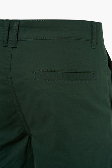 Short vert de PRIVATE BLUE, avec poche arrière passepoilée et passants de ceinture.