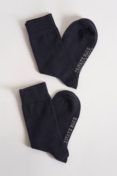 Blauwe sokken van PRIVATE BLUE, platliggend op een witte achtergrond.