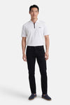 Pantalon coloré noir de PRIVATE BLUE, porté avec un polo blanc et des mocassins bleus marine.