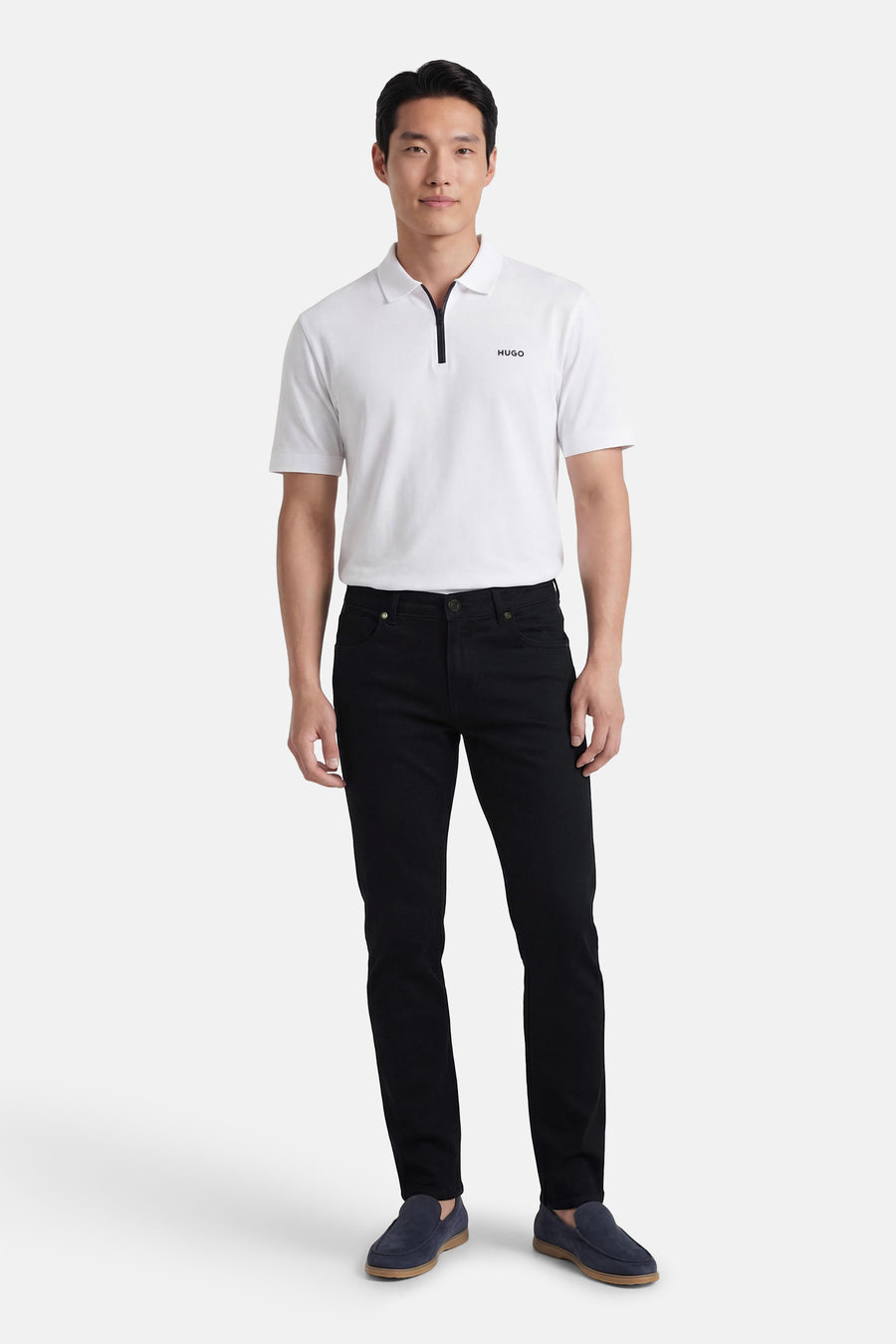 Pantalon coloré noir de PRIVATE BLUE, porté avec un polo blanc et des mocassins bleus marine.