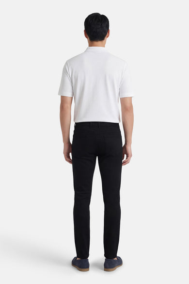 Zwarte broek van PRIVATE BLUE, gedragen met een witte polo en blauwe loafers, achtergezicht.