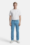 Kleurrijke blauwe broek van PRIVATE BLUE, gedragen met een wit T-shirt en witte sportschoenen.