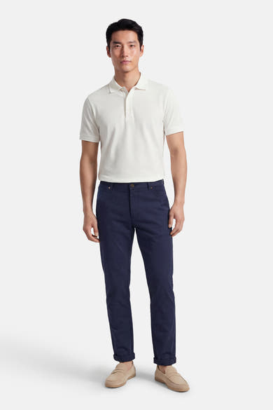 Pantalon coloré bleu de PRIVATE BLUE, porté avec un polo blanc et des mocassins en daim.