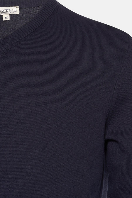 Marineblauwe V-hals trui van PRIVATE BLUE, zichtbare gebreide textuur en klassieke pasvorm.