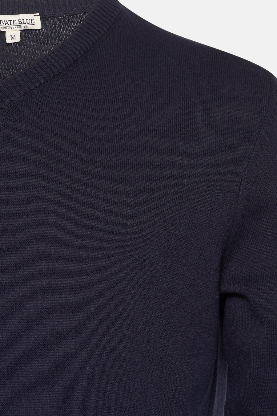 Marineblauwe V-hals trui van PRIVATE BLUE, zichtbare gebreide textuur en klassieke pasvorm.
