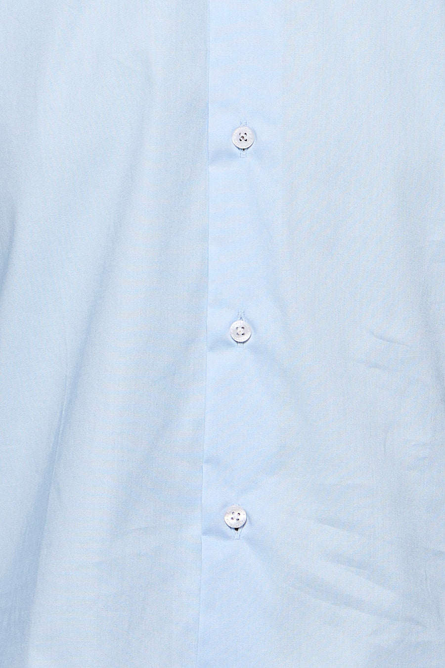 Gros plan sur une chemise bleu clair à manches longues avec une patte de boutonnage et trois boutons blancs visibles.