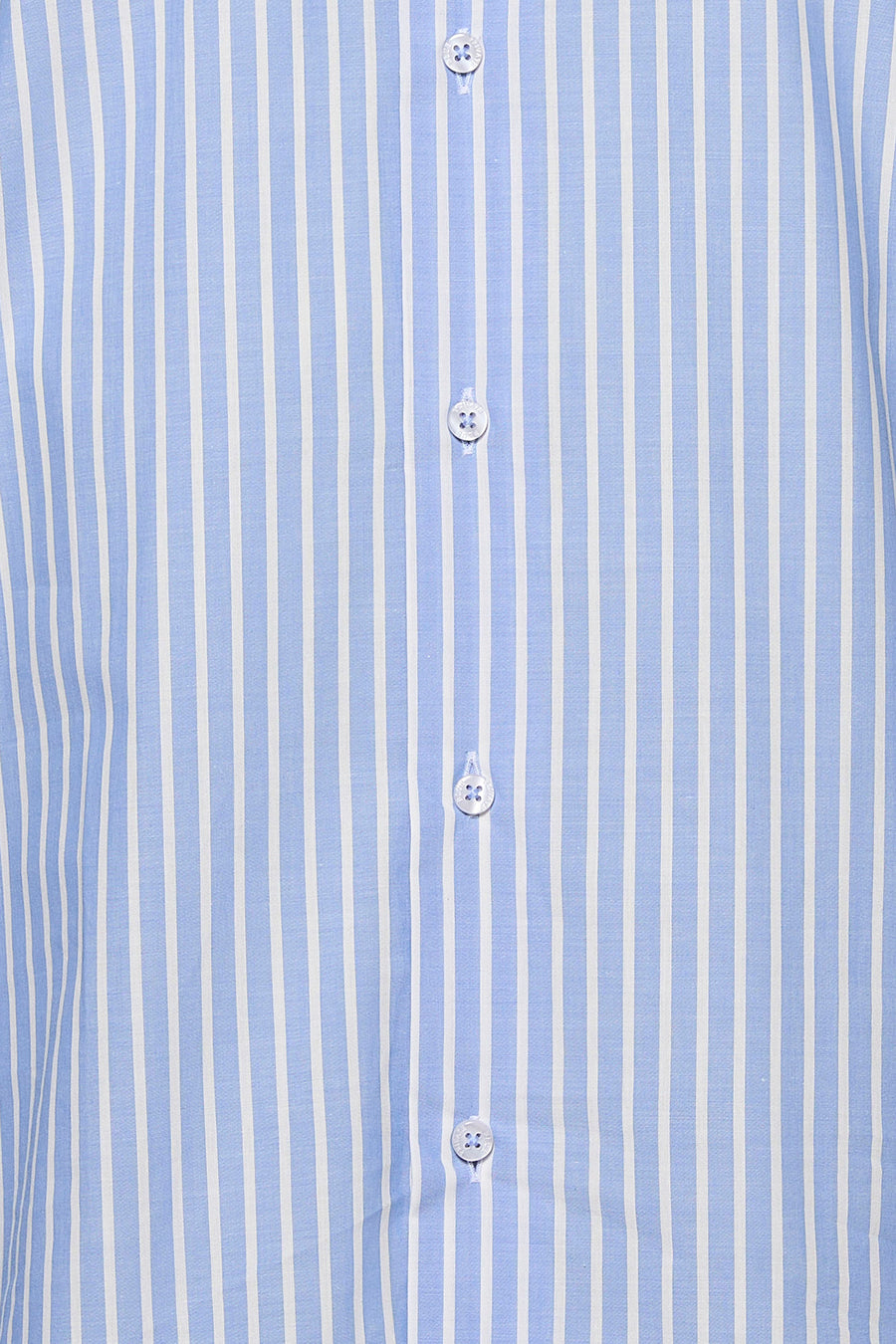 Détail d’une chemise à manches longues bleu clair à rayures blanches, avec boutons blancs.