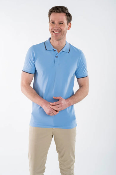 Polo bleu par PRESLY & SUN, avec col et bordures de manches marron foncé, porté avec un pantalon beige.
