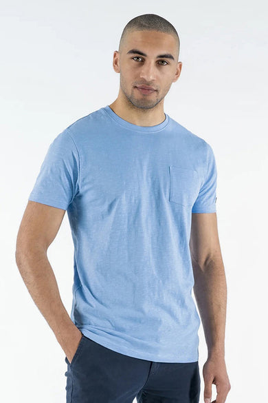 T-shirt bleu à manches courtes de PRESLY & SUN, avec poche poitrine et porté avec un pantalon marine.