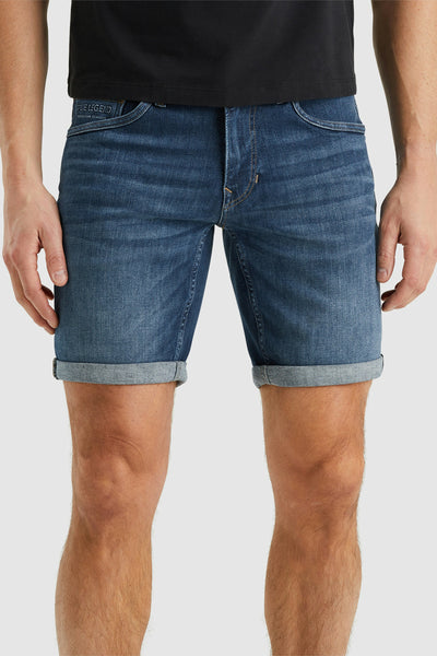 Short en denim bleu de PME Legend, avec ourlet roulé et porté avec un t-shirt noir.
