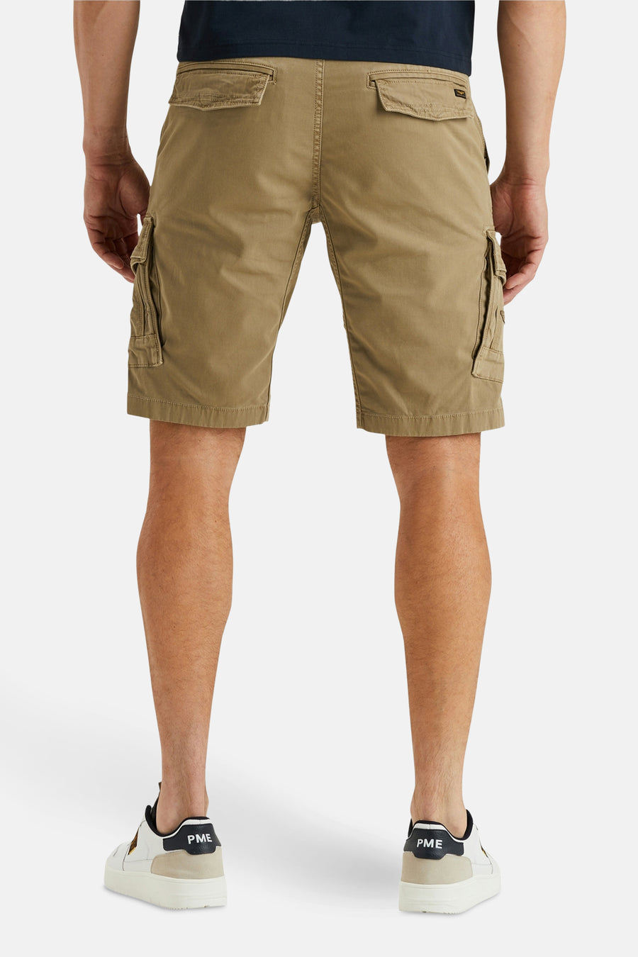 Korte beige cargo van Pme Legend, met zij- en achterzakken, gedragen met witte schoenen.