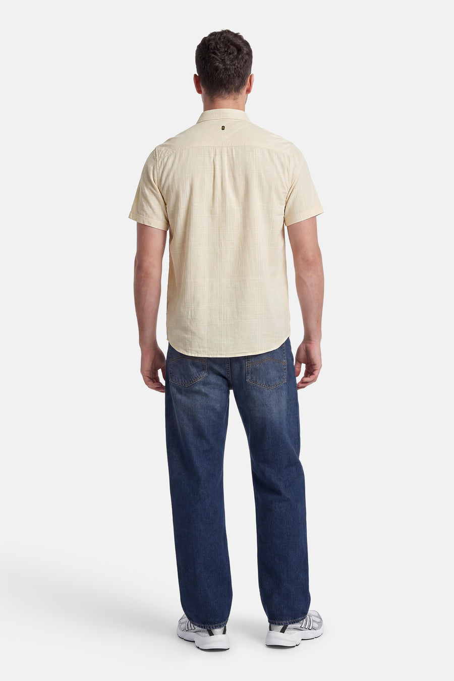 Chemise jaune à manches courtes de PME LEGEND, motif quadrillé et logo au dos, portée de dos avec un jean foncé.