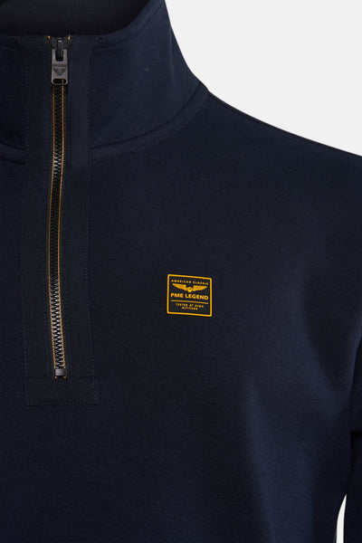 Sweat col montant bleu de PME Legend, avec fermeture éclair apparente et écusson décoratif.