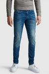 Slim jeans in donkerblauw denim van Pme Legend, gedragen met een grijze trui en witte sneakers.