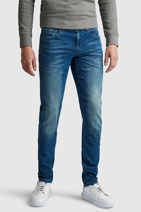 Jean slim en denim bleu foncé de Pme Legend, porté avec un pull gris et des baskets blanches.