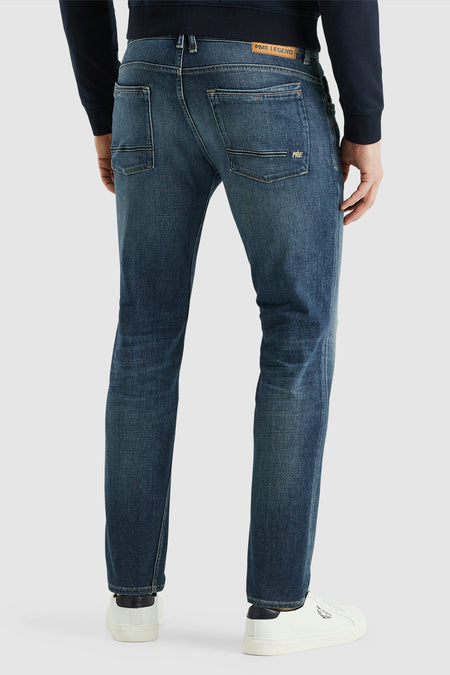 Jean fuselé bleu de PME Legend, avec des poches arrière passepoilées et un patch en cuir à la taille.