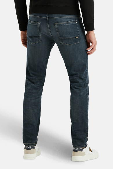 Jean droit en denim bleu foncé de PME Legend, avec poches arrière et chaussures blanches.