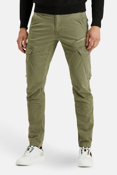 Groene cargobroek van PME Legend, met cargozakken aan de zijkant en gedragen met een zwarte trui en witte sneakers.