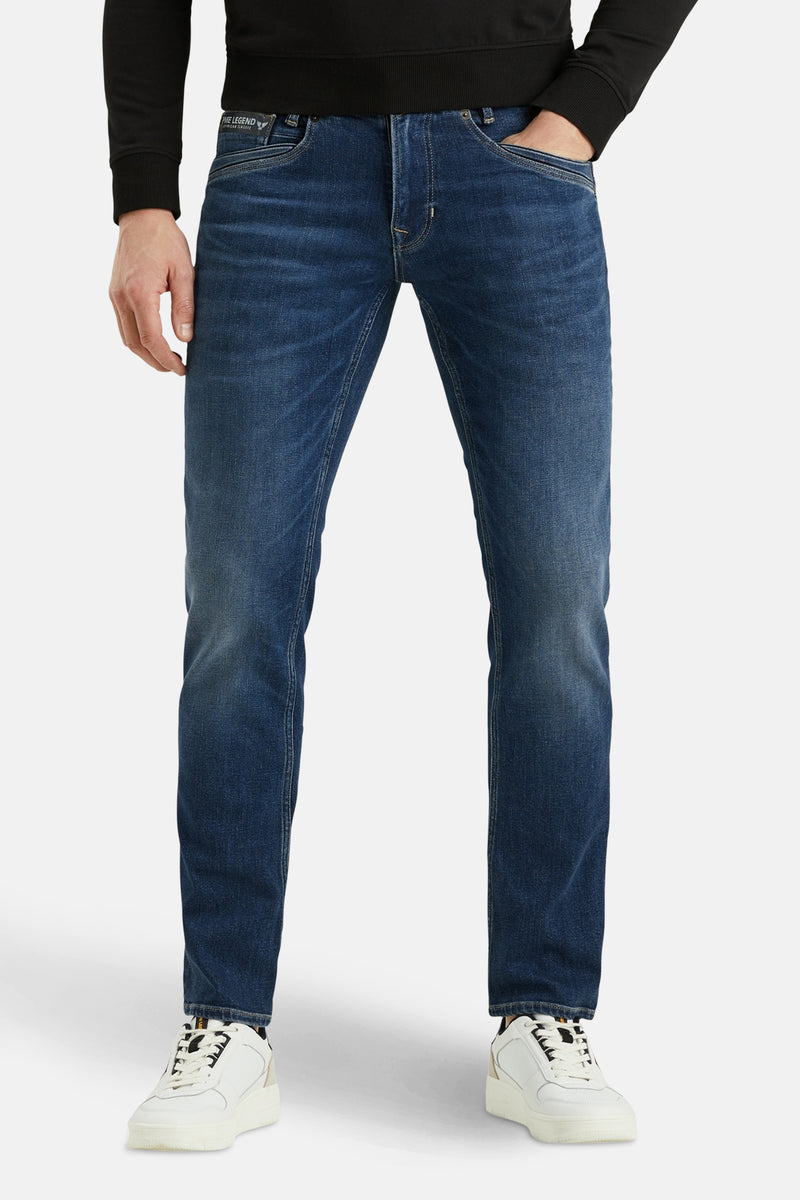 Middenblauwe rechte jeans van PME Legend, met achterzakken en witte sportschoenen.