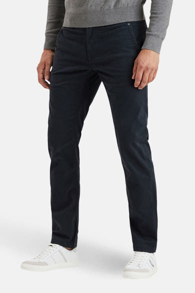 Blauwe chino van PME Legend, gedragen met een grijze trui en witte sneakers.