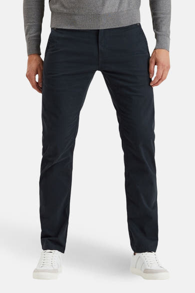 Blauwe chino van PME Legend gedragen met een grijze trui en witte sneakers.