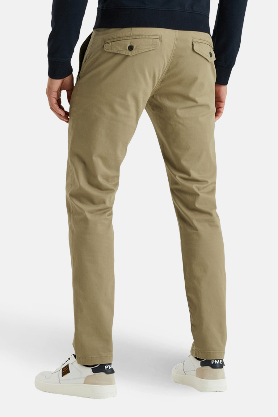 Chino beige de PME Legend, porté avec un pull bleu marine et des baskets blanches.