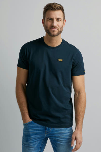 T-shirt bleu à manches courtes de Pme Legend, avec un petit logo sur la poitrine, porté avec un jean.