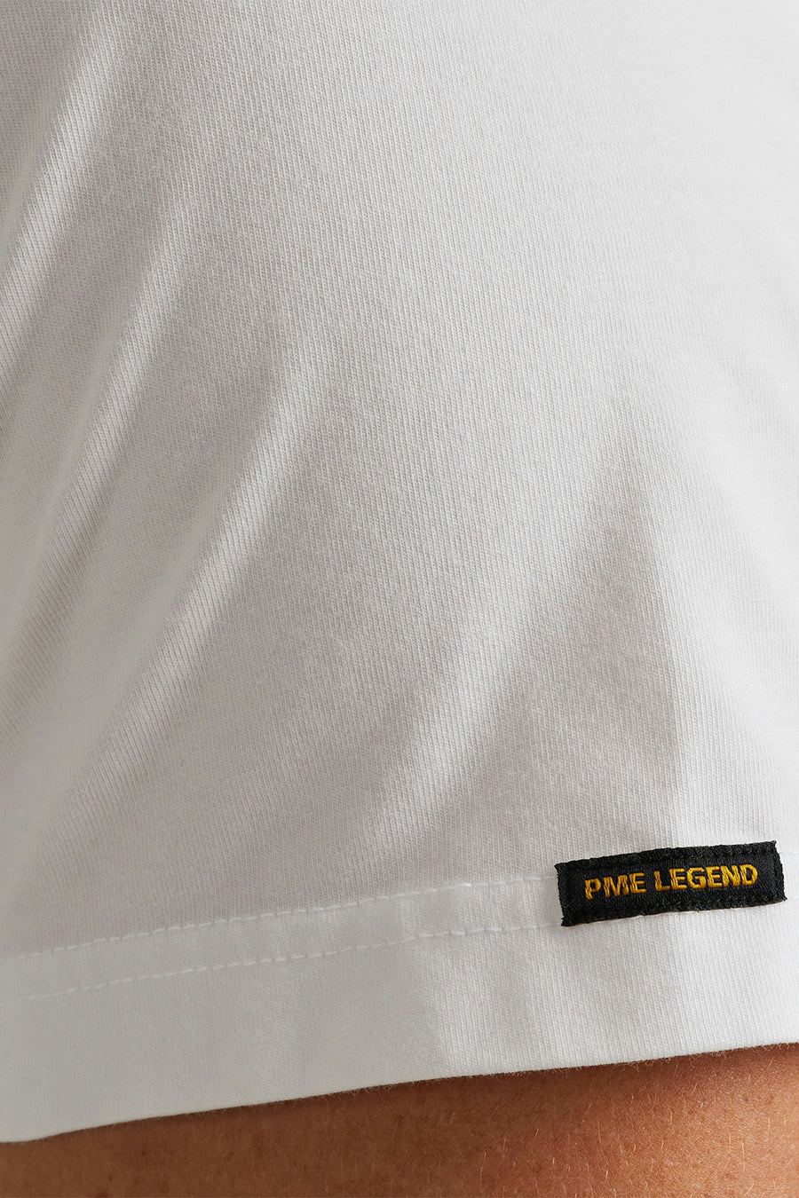 T-shirt blanc de Pme Legend, avec une étiquette noire cousue sur le bord.