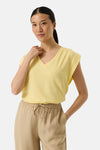 Top jaune de GARCIA, col en V, sans manches, avec détails brodés sur les épaules, porté avec un pantalon beige.