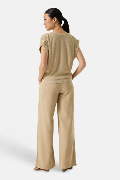 Top sans manches doré de GARCIA, en maille légère froncée aux épaules, porté de dos avec un pantalon large beige.