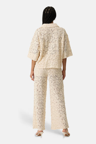 Chemise beige à manches courtes de GARCIA en dentelle florale texturée, portée avec un pantalon assorti, vue de dos.
