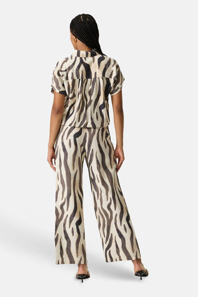 Pantalon multicolore de GARCIA à imprimé zèbre, coupe large, porté avec un chemisier assorti, vue de dos.