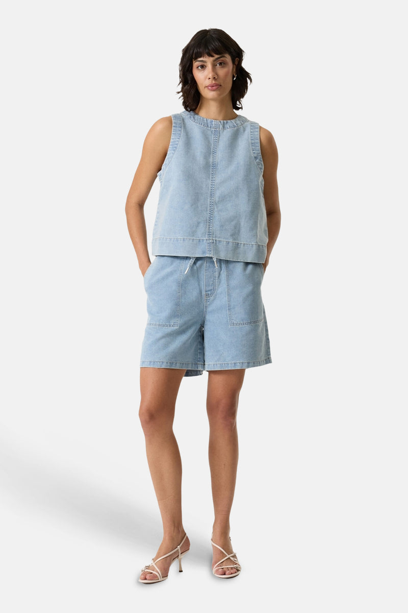 Short bermuda en jean bleu clair de GARCIA, à taille élastique avec cordon et poches plaquées, porté avec un haut en denim assorti et des sandales blanches à talons.