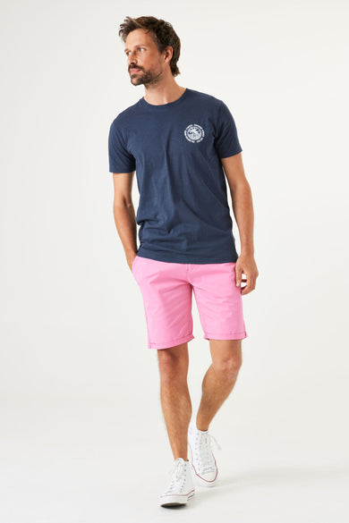 T-shirt bleu à manches courtes de GARCIA, avec un imprimé sur la poitrine, porté avec un short rose.