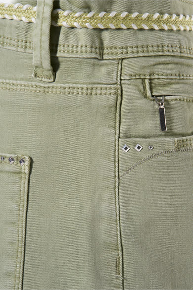 Pantalon vert par ZABAIONE avec ceinture tressée, poche zippée et rivets décoratifs.
