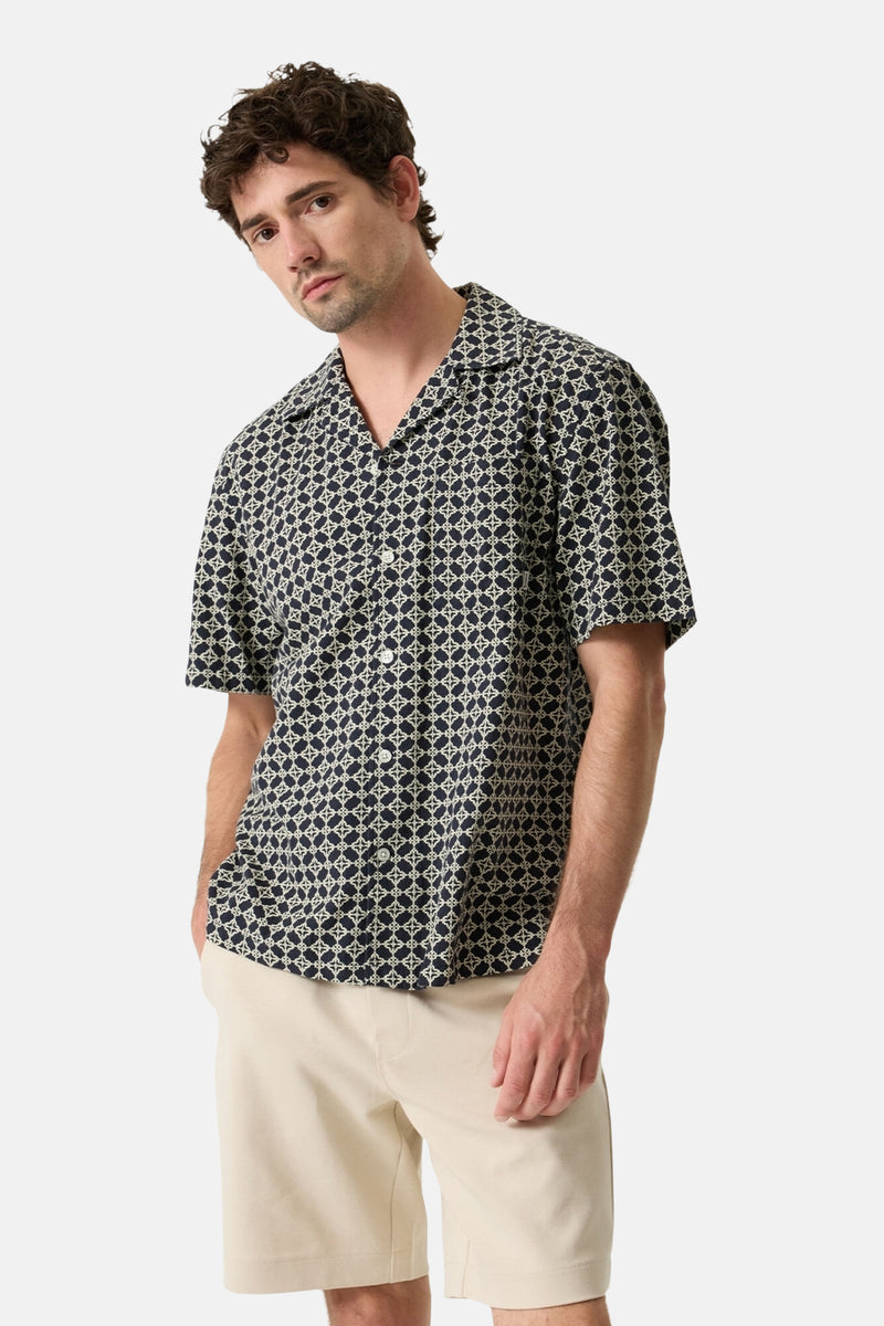 Multicolored short-sleeve chemise with geometric print, worn by model in front view with beige shorts