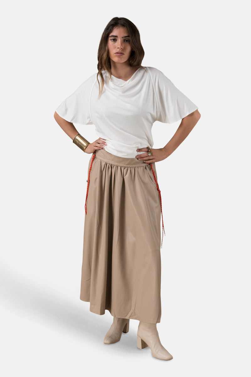Wit T-shirt met korte mouwen van ADORE, gedragen met een beige rok en enkellaarsjes.