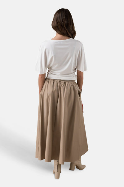 Wit T-shirt met korte mouwen van ADORE, gedragen met een bruine rok met hoge taille en enkellaarsjes.