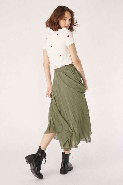 Olive green pleated 3/4 length skirt with asymmetrical hem and elastic waist, worn with white heart-embroidered top and black combat boots, side view