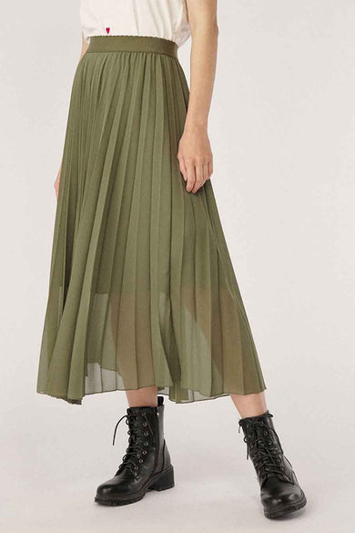 Olive green pleated 3/4 length skirt with sheer overlay, worn with black combat boots, front view