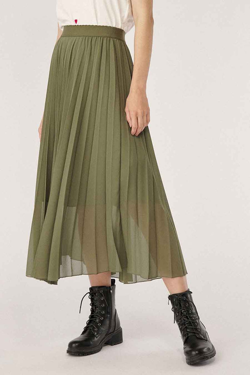 Olive green pleated 3/4 length skirt with sheer overlay, worn with black combat boots, front view