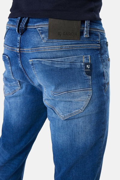Jean droit bleu délavé en denim de GARCIA, avec poches arrière et patch logo en cuir à la taille.
